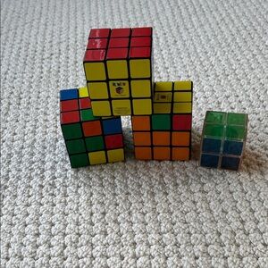 Set of three regular sized and one mini Rubik‘s cubes